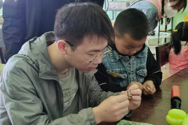 904def12c5de4395a35623d3e1090a02.jpg 志愿者和小朋友一起做益智游戏.jpg